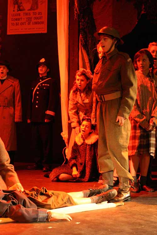 Soldier, police and chorus during Blitz scene