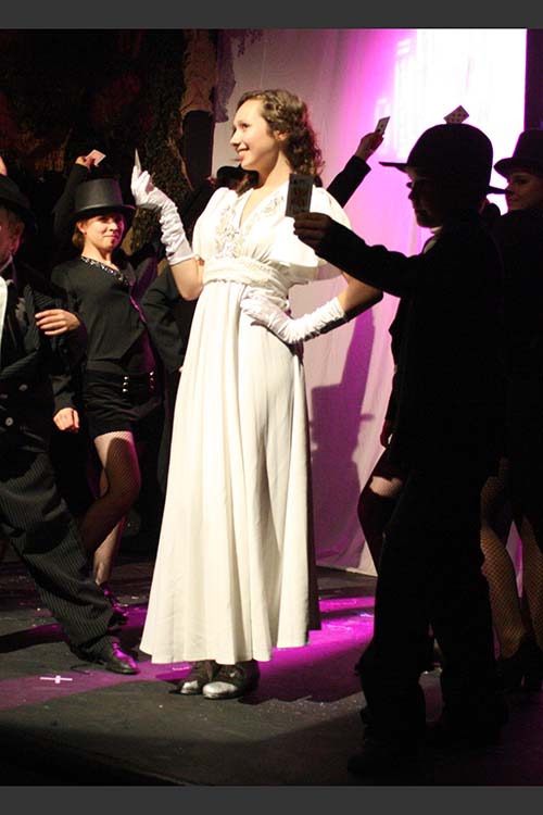 Chorus and girl in white dress at the cinema